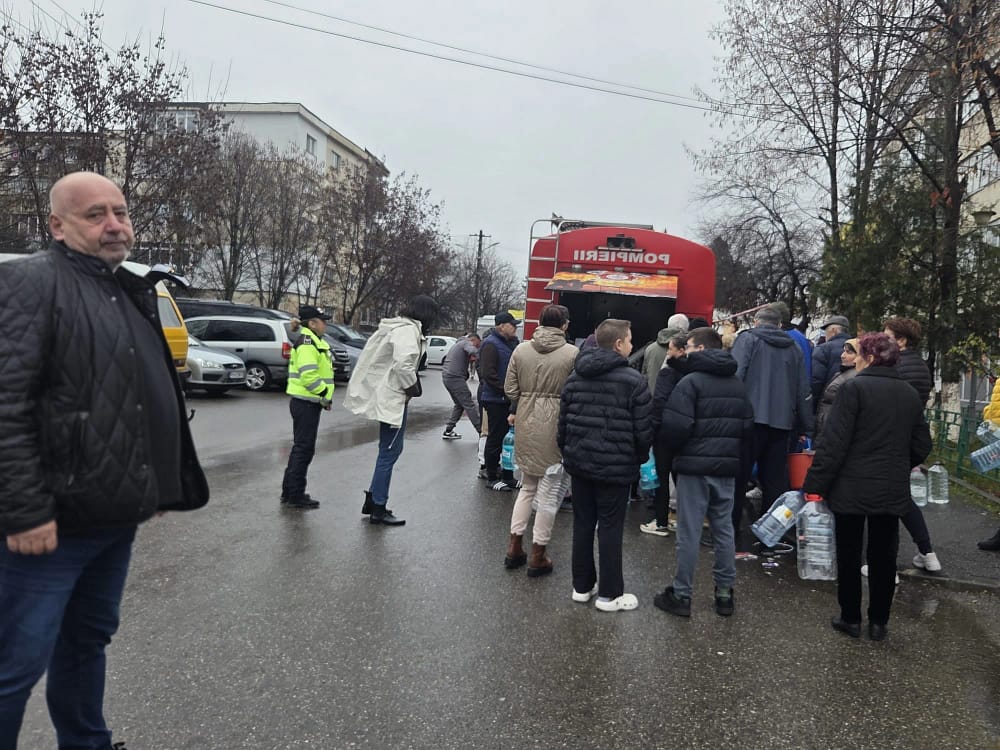 Oameni care așteaptă să-și umple bidoanele cu apă potabilă