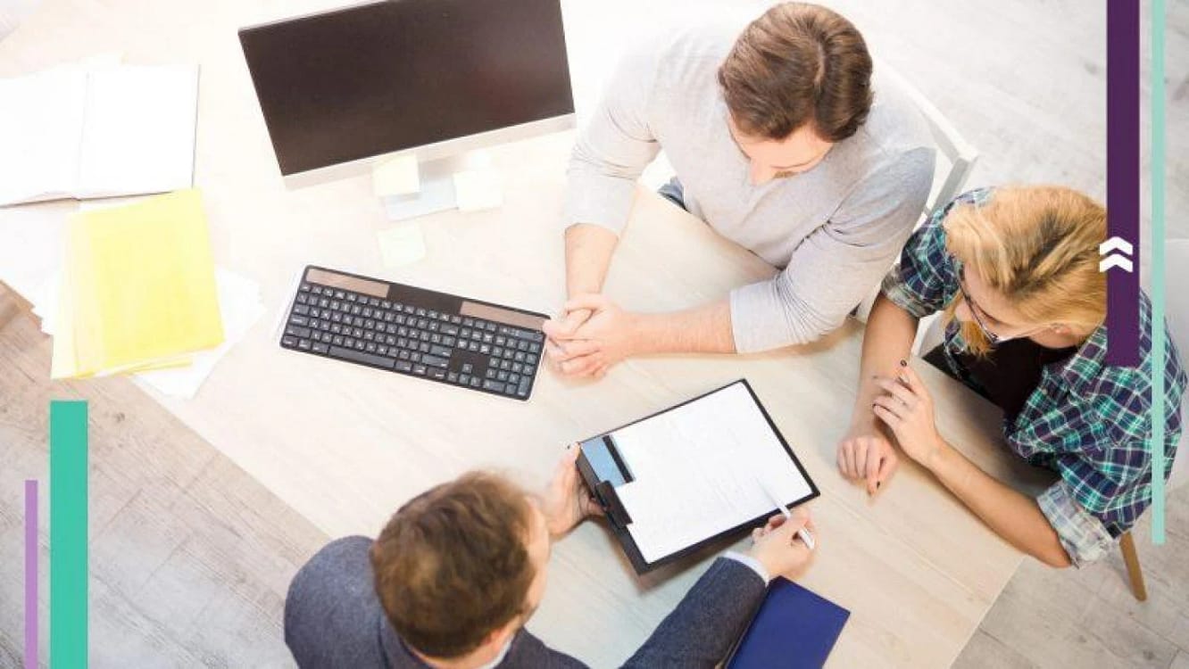 Doi tineri discută cu un ofițer bancar despre un credit