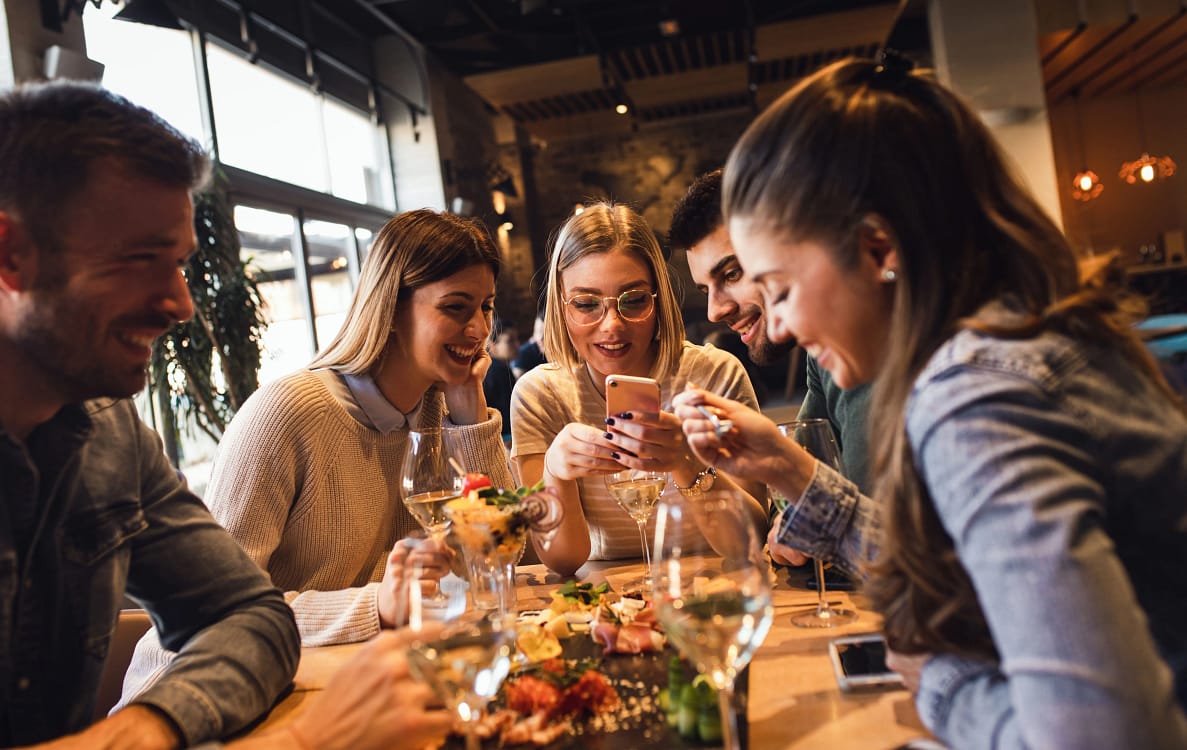 Cinci tineri la masă într-un restaurant