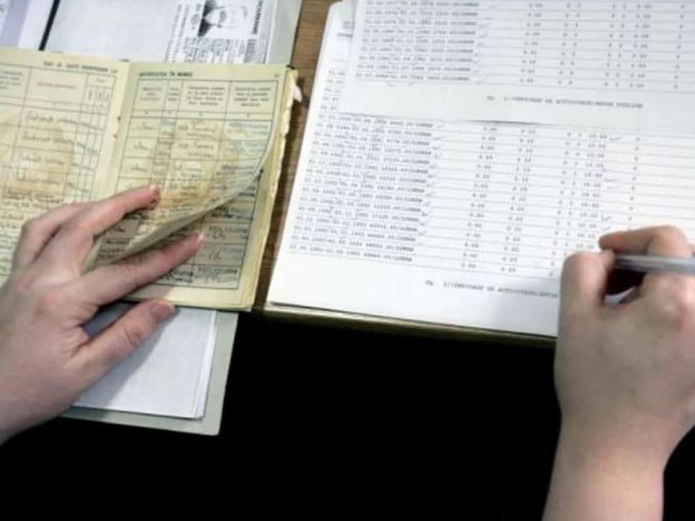 Cineva transcrie datele din carrtea de muncă într-un registru