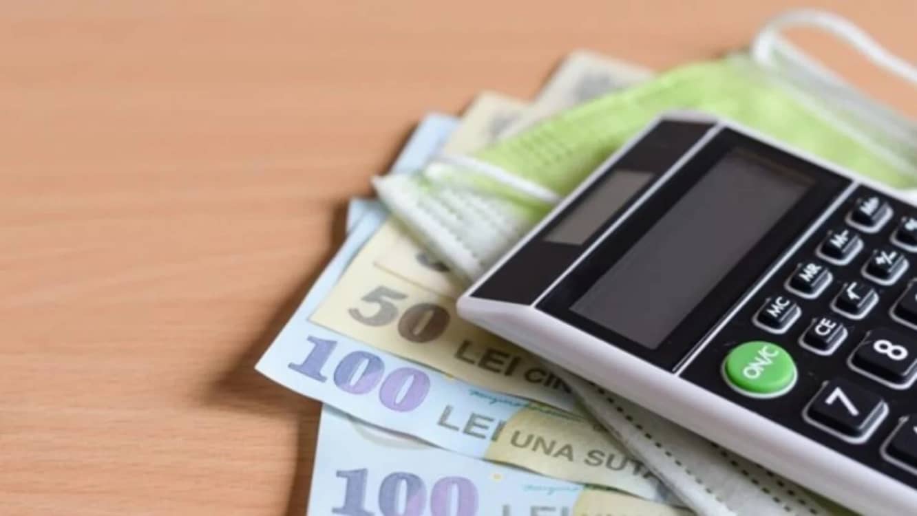 Un calculator așezat pe mai multe bancnote de 50 și 100 de lei