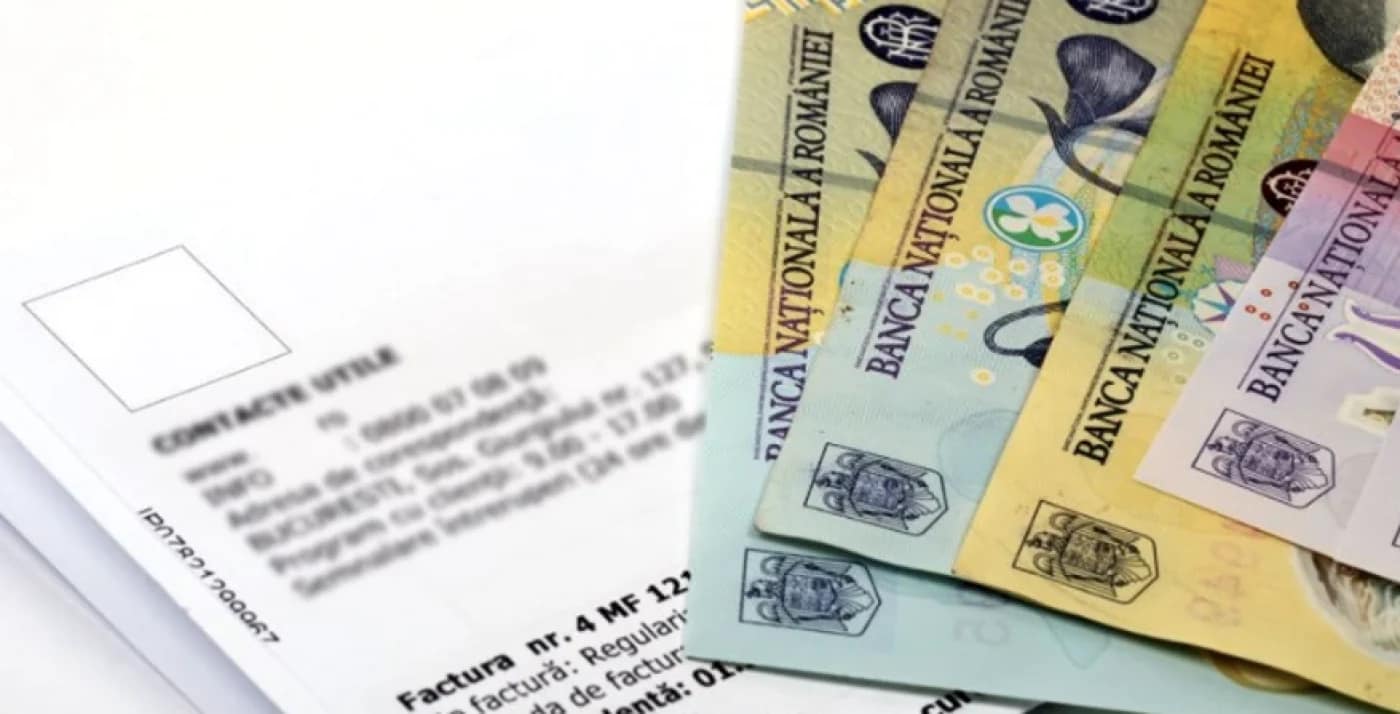 Bancnote de 100 și 50 de lei puse peste o factură la energia electrică